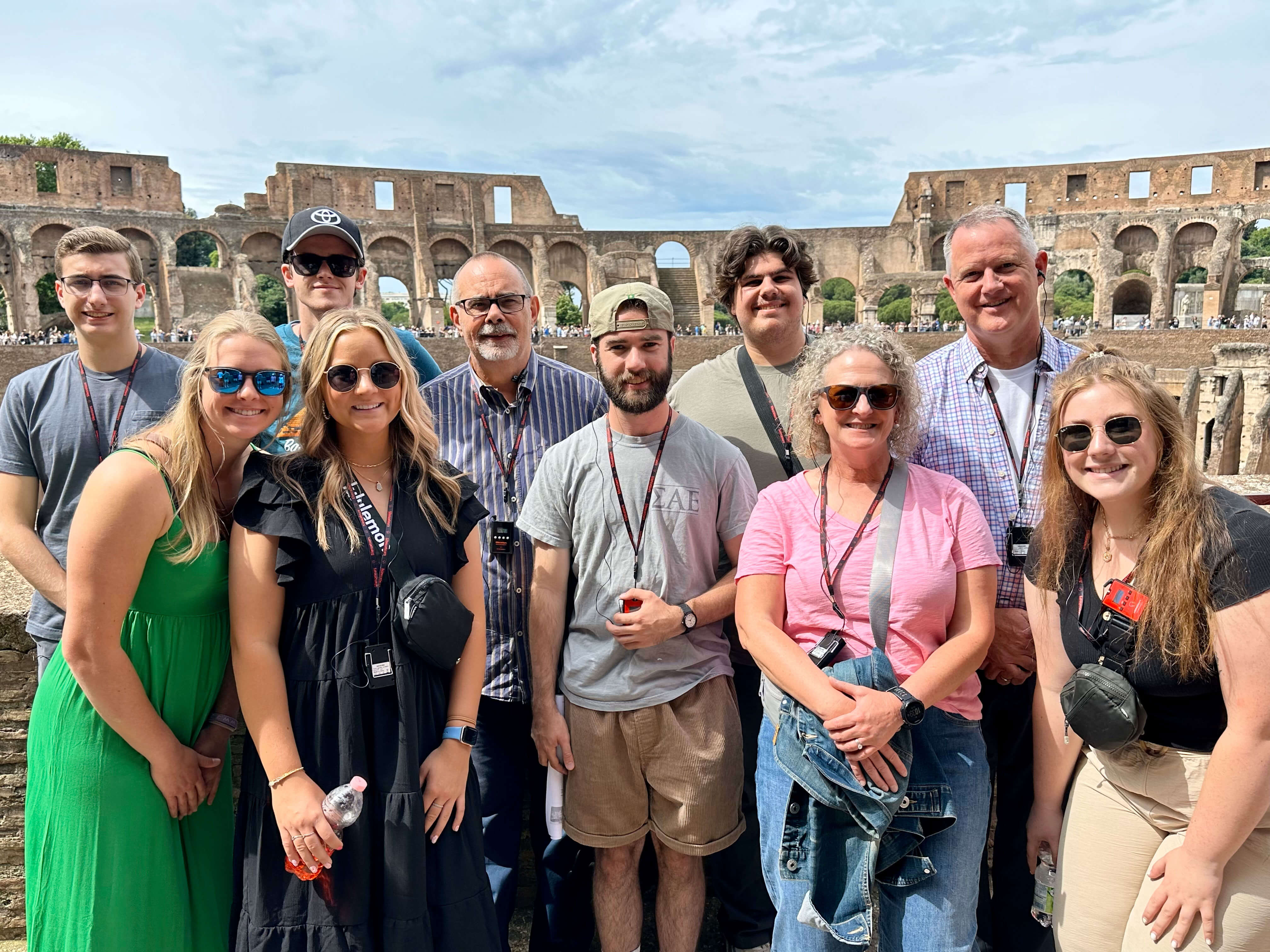 Students and faculty stand in front of historical ruins